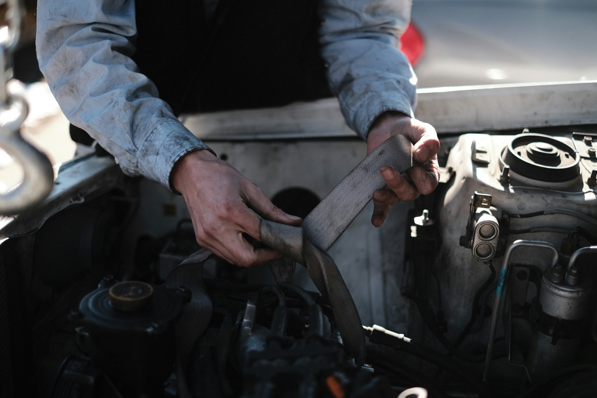 Un hombre está trabajando en el motor de un coche.
